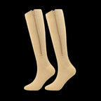 Pair of beige knee-high socks with zippers on a white background